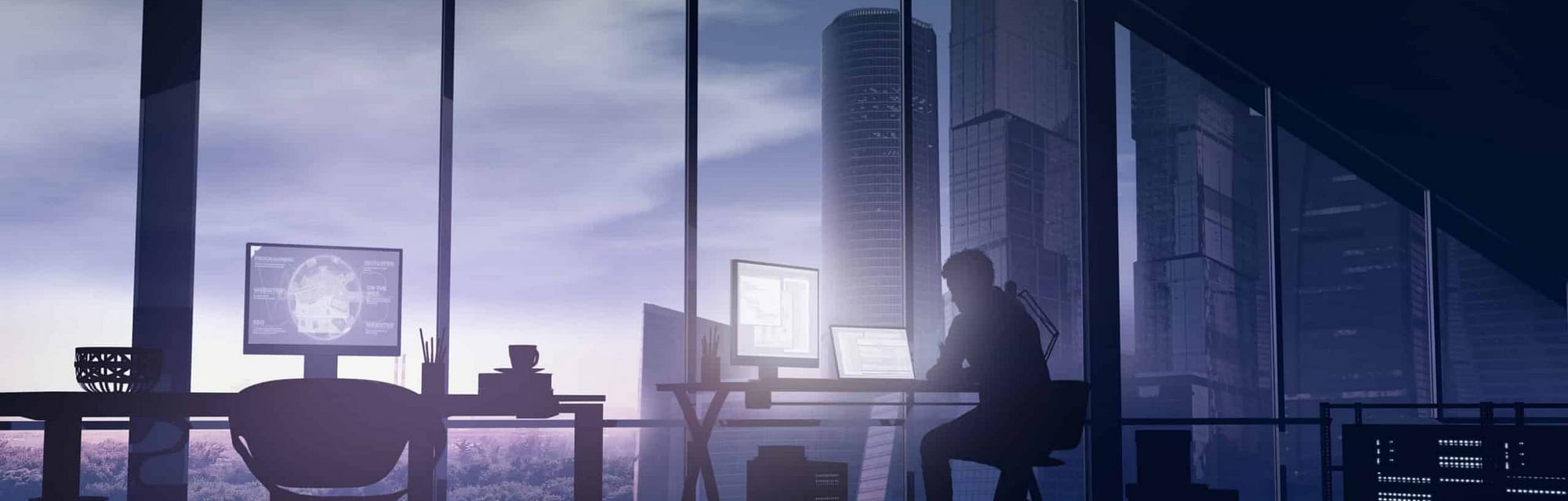 Silhouette of a web programmer sitting in his office with panoramic windows on skyscrapers.